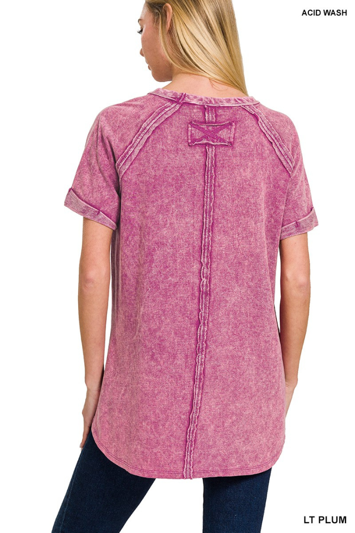 A woman seen from the back wearing a short-sleeved, round-hemmed, acid-wash French terry pullover in a shade of plum, featuring cuffed sleeves, a double back seam, and a back patch detail.