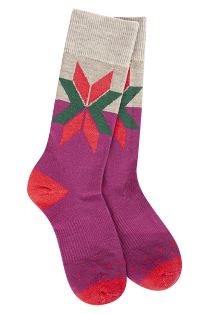 A pair of World's Softest Woods Crew socks in Boysenberry Fair Isle pattern, featuring a grey cuff and heel, a vibrant fuchsia leg with a large, colorful star-like motif in red and green, and a red toe.