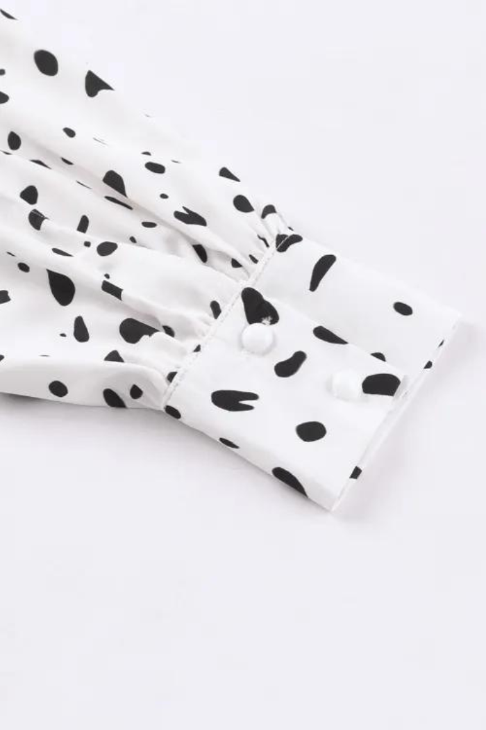 White shirt with black polka dot pattern on a white background