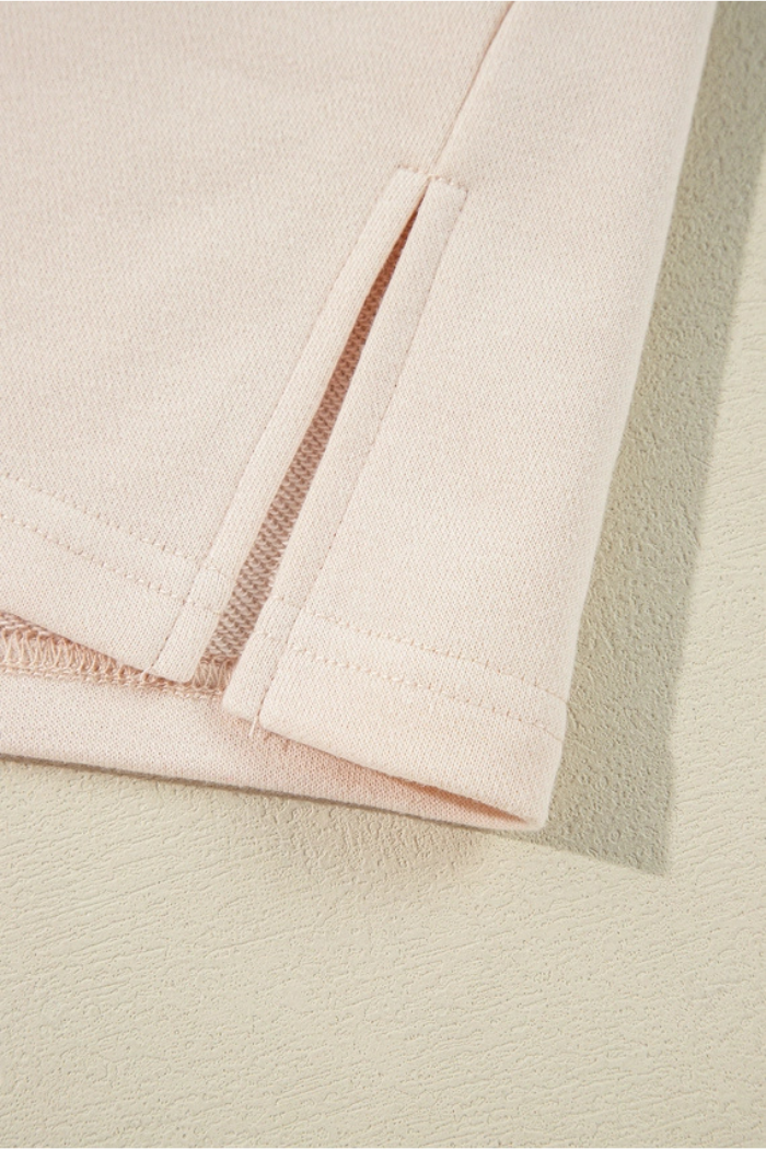 A close-up of a beige fabric featuring a vertical slit or vent with an exposed seam detail.