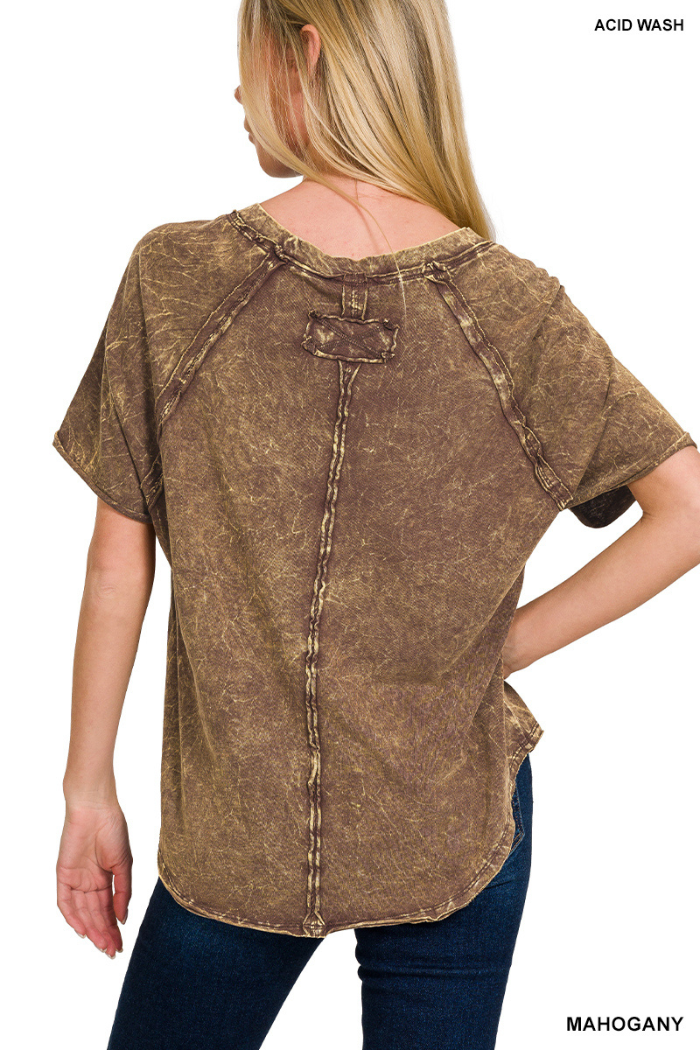 A woman wearing a mahogany-colored, acid-wash short-sleeved top with visible seams and a distressed texture. The text "ACID WASH" is visible in the top right corner and "MAHOGANY" in the bottom right corner of the image.