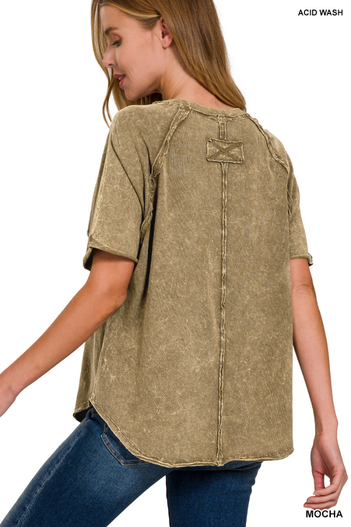A close-up view of the back of a light brown or mocha-colored garment, likely a shirt or sweatshirt, showing a distressed or vintage-washed texture. A prominent stitched detail resembling a rectangular patch with an "X" pattern is centered on the upper back, connected by a vertical seam extending downwards. The word "MOCHA" is visible in white text in the bottom right corner of the image.