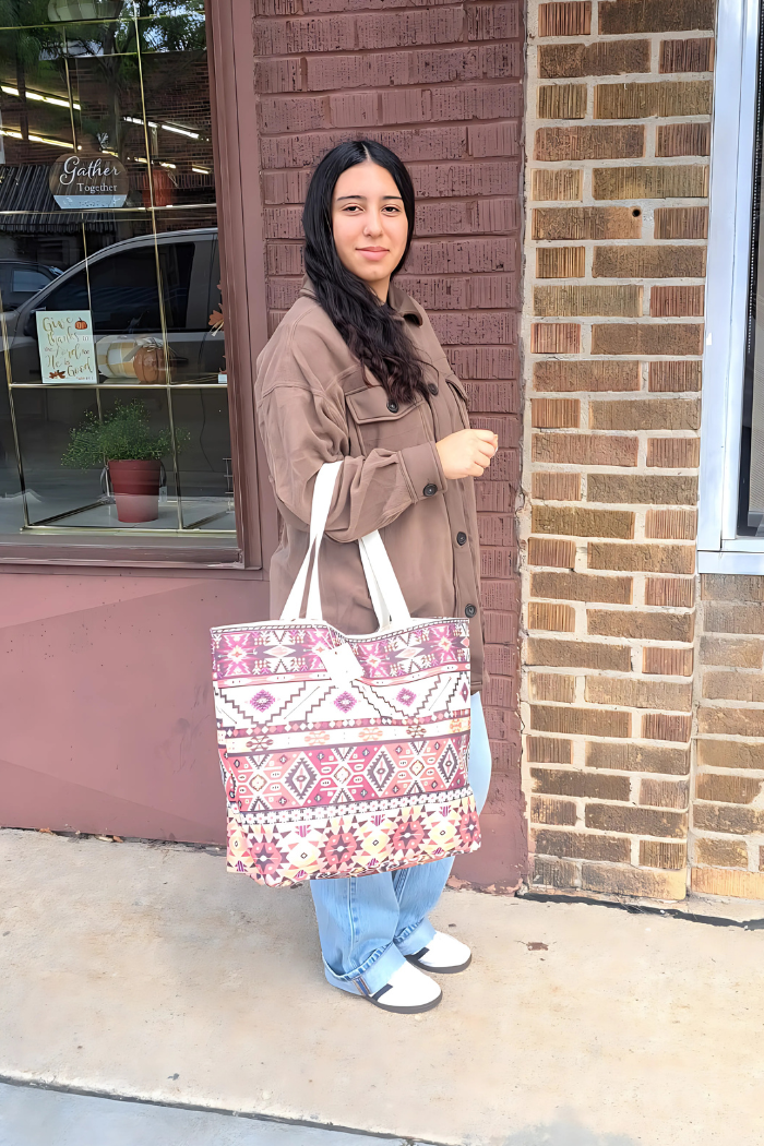 The image features a woman wearing a Southwestern or Aztec print canvas tote bag and a brown oversized "shacket" (shirt-jacket).