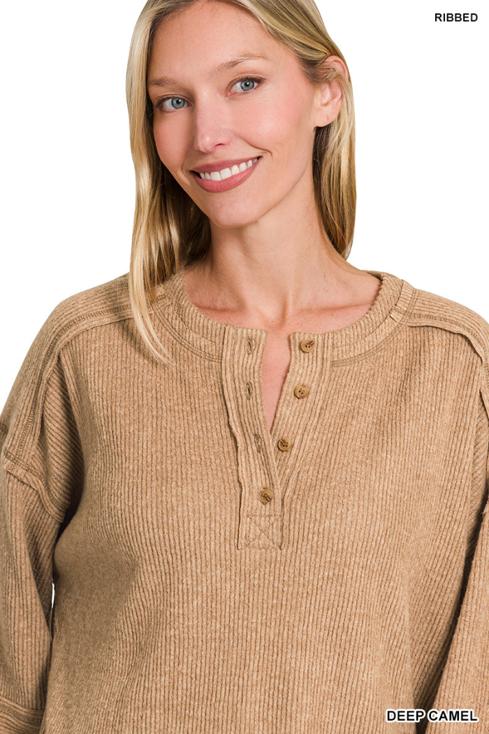 A woman with long blonde hair smiles at the camera, wearing the Brushed Ribbed Henley Top in a cozy, relaxed loungewear style against a white background.