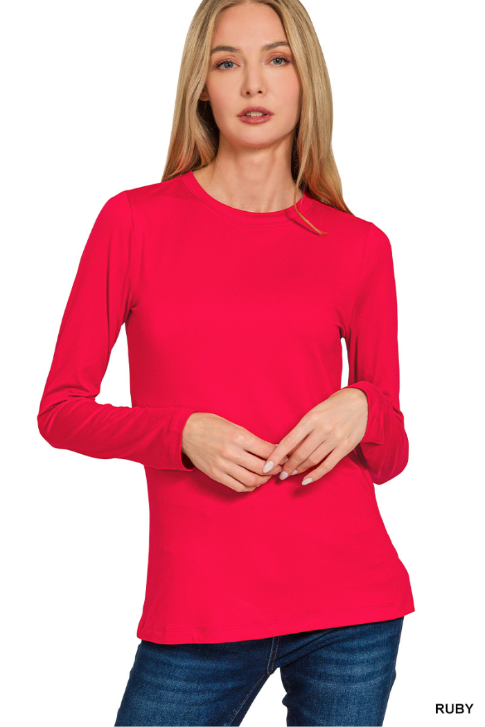 A woman with long blonde hair wears a buttery soft Brushed Microfiber Long Sleeve Top in RUBY and blue jeans, standing against a white background. The shirt color is labeled as RUBY in the bottom right corner.