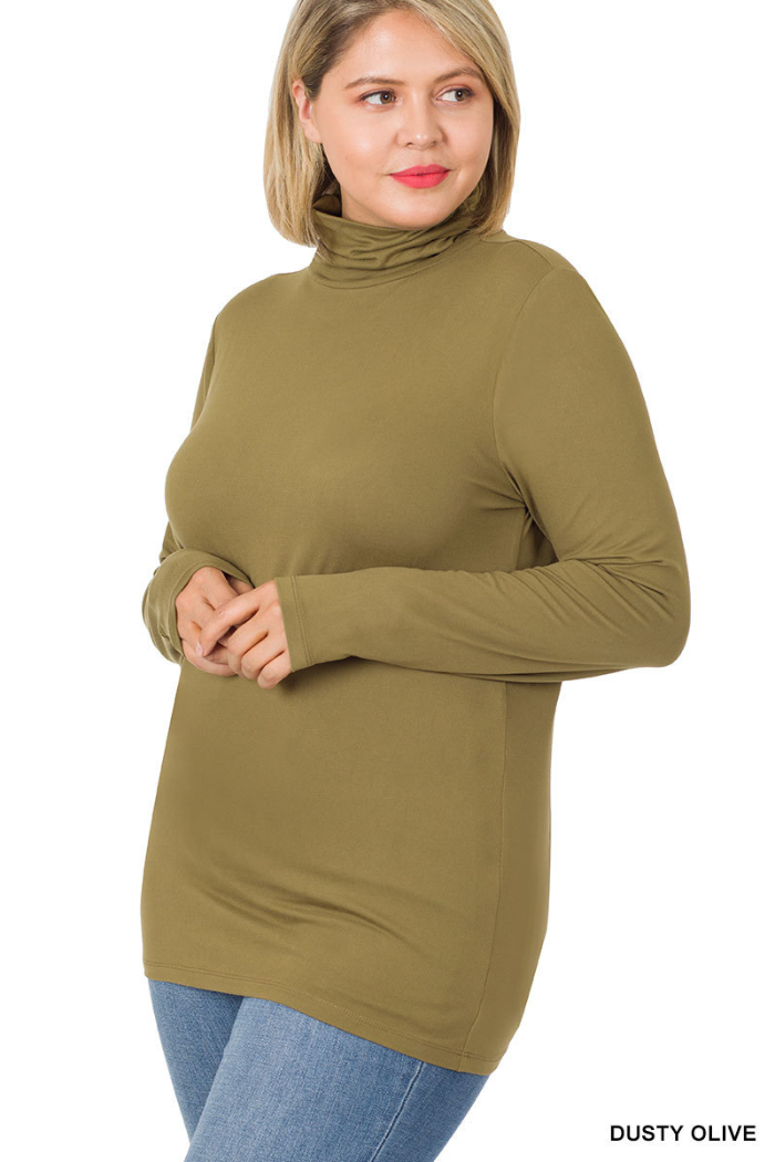 A blonde woman wears the Plus Premium Microfiber Mock Neck Top in dusty olive and light blue jeans, standing with hands clasped and smiling to the side against a white background.