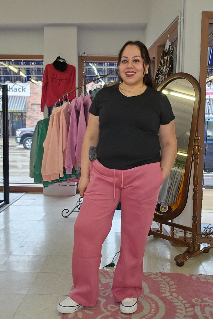 A woman wearing the Cotton V-Neck Tee with a relaxed silhouette stands in front of a mirror, embracing Divatee Exclusive style.