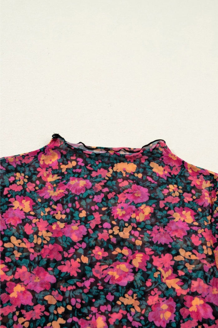 A close-up of the Floral Mock Neck Top made from lightweight mesh, featuring a vibrant pink, orange, and green floral pattern on black. The vintage-inspired piece is shown against a plain light background.
