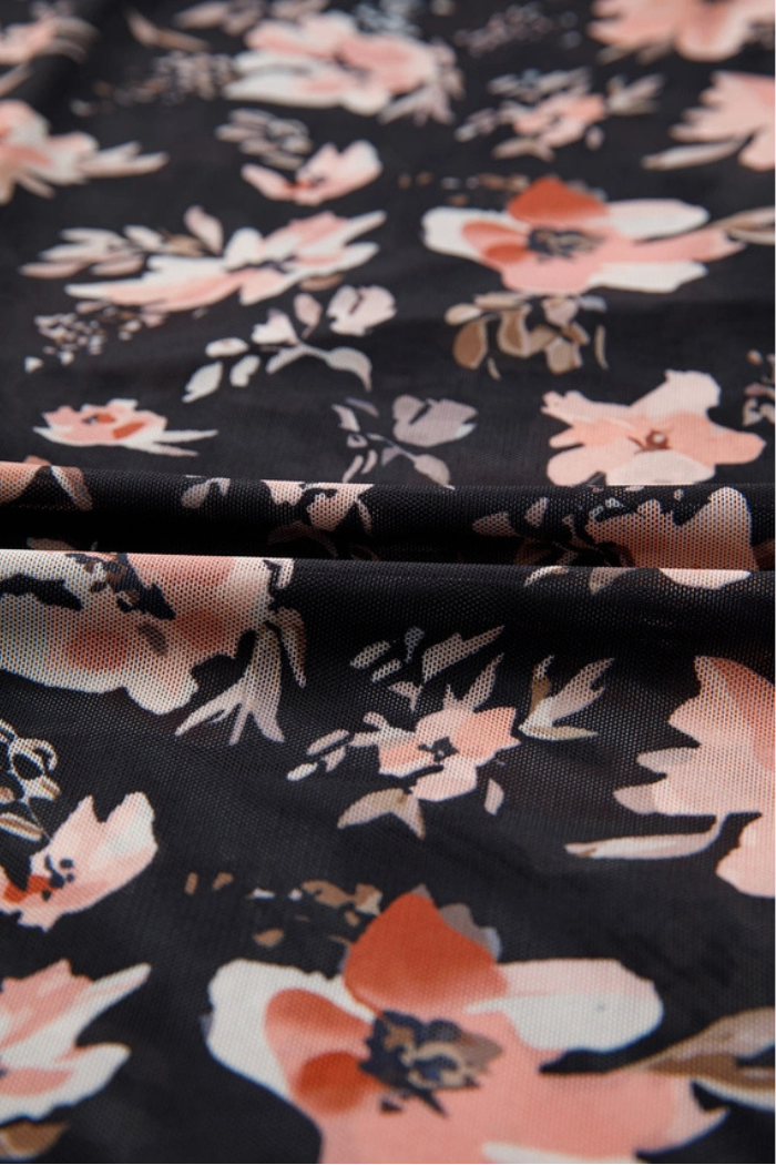 A close-up of the Floral Mesh Mock Neck Top shows black fabric with a floral print—pink, peach, and white flowers, green leaves—and a visible horizontal crease across the material.