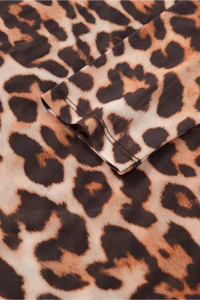Close-up of folded fabric with a bold brown and black animal print on tan, ideal for crafting the Leopard Mesh Mock Neck Top.