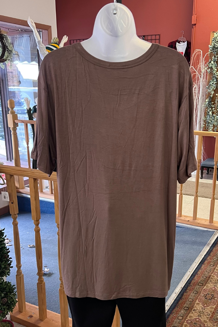 A Plus Size Rayon Tee by Zenana Premium, shown on a mannequin in-store with wooden railings and decorations behind; made from a soft rayon blend for comfortable everyday wear.