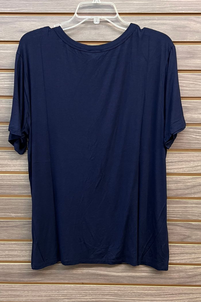 The Plus Size Rayon Tee, a plain navy blue short-sleeve top by Zenana Premium, hangs on a clear plastic hanger against a wooden slat wall and is crafted from a soft rayon blend for comfort.