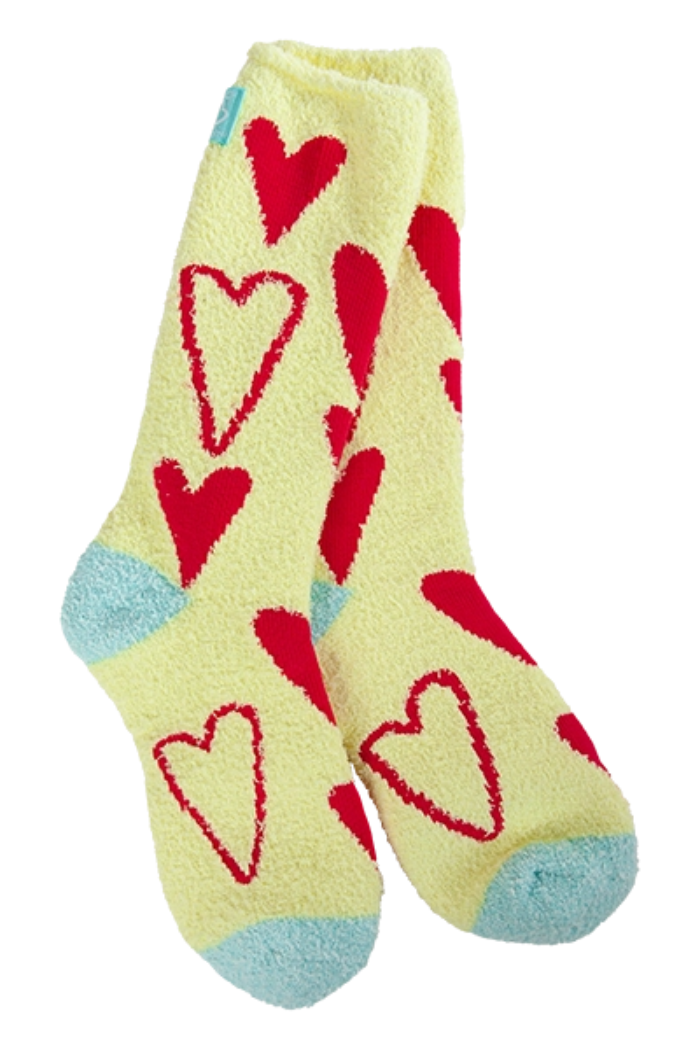 The Holiday Valentine Cozy Crew features ultra-soft fuzzy yellow socks with red heart patterns and light blue toe and heel accents, displayed on a white background.
