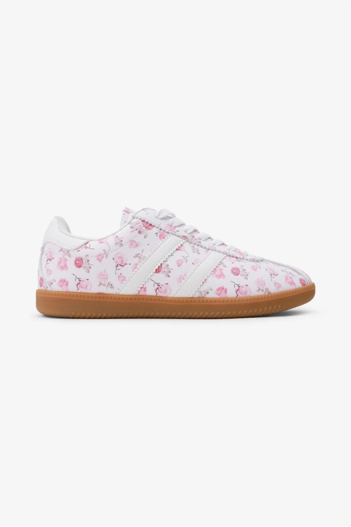 Floral Lace-Up Sneakers crafted from vegan leather feature pink floral patterns, white laces, three white side stripes, and a brown rubber sole. Displayed on a plain white background.