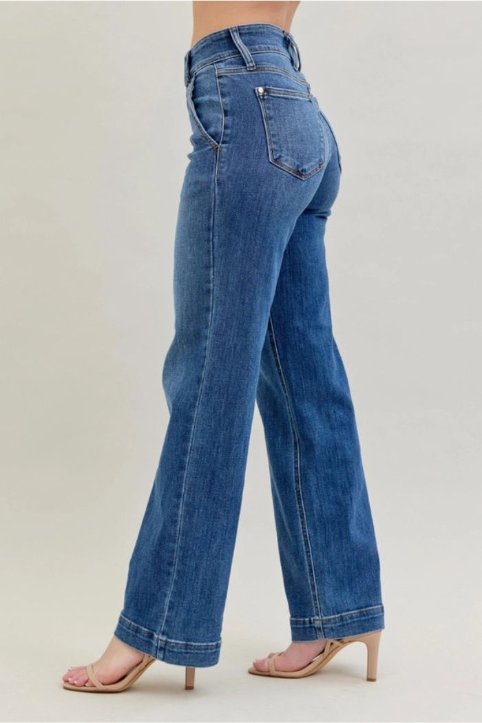 A person wearing High Waist Wide Leg Jeans and nude heeled sandals stands against a plain light background, shown from the side and slightly from the back.