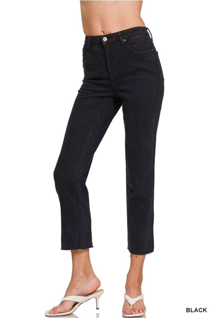 Someone wearing Acid Wash Crop Pants—black, high-rise, straight-leg cropped jeans with a raw hem—paired with white heeled sandals. The word BLACK appears in the bottom right corner.