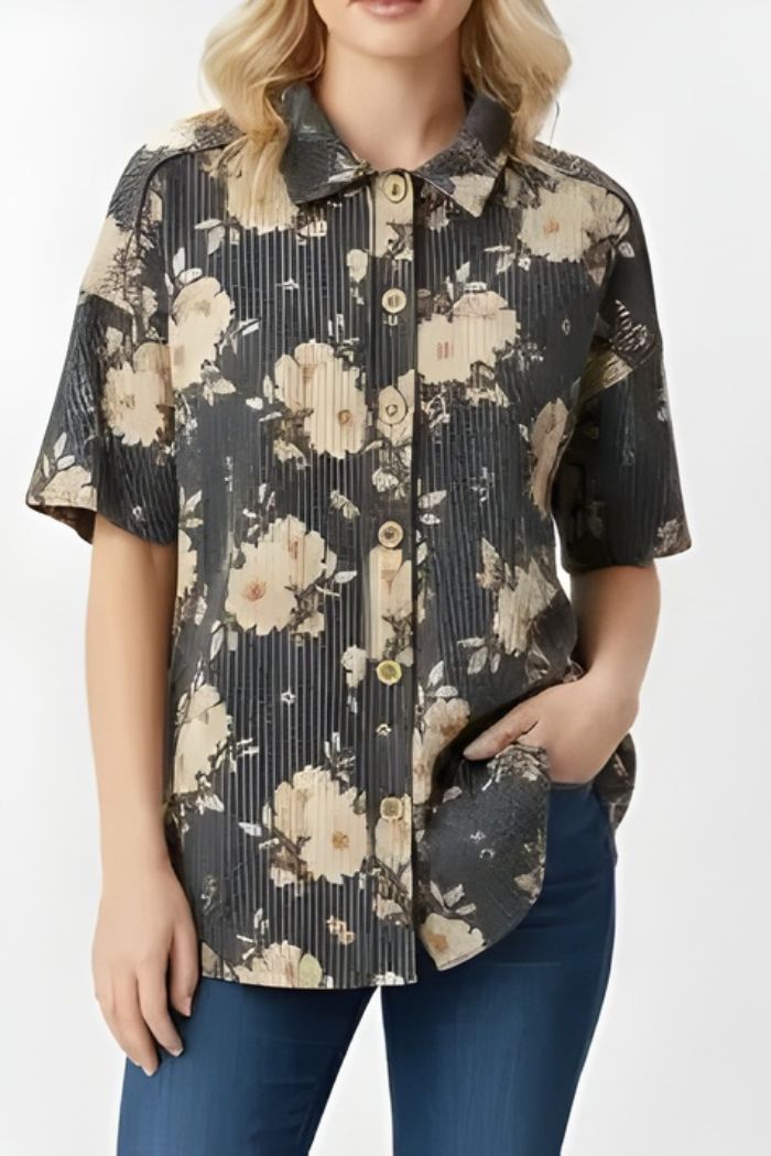 A woman wears the Floral Ribbed Button Top—beige with a floral ribbed design and buttons—paired with blue pants. One hand is in her pocket, the image is cropped at the knees, and her face isn't visible.