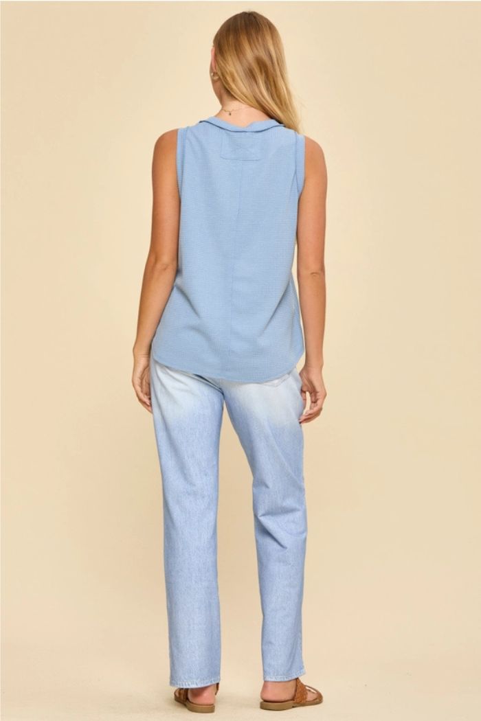 A woman with long blonde hair stands with her back to the camera, wearing a Basic Knit Tank Top in light blue, matching jeans, and brown sandals against a plain beige background.