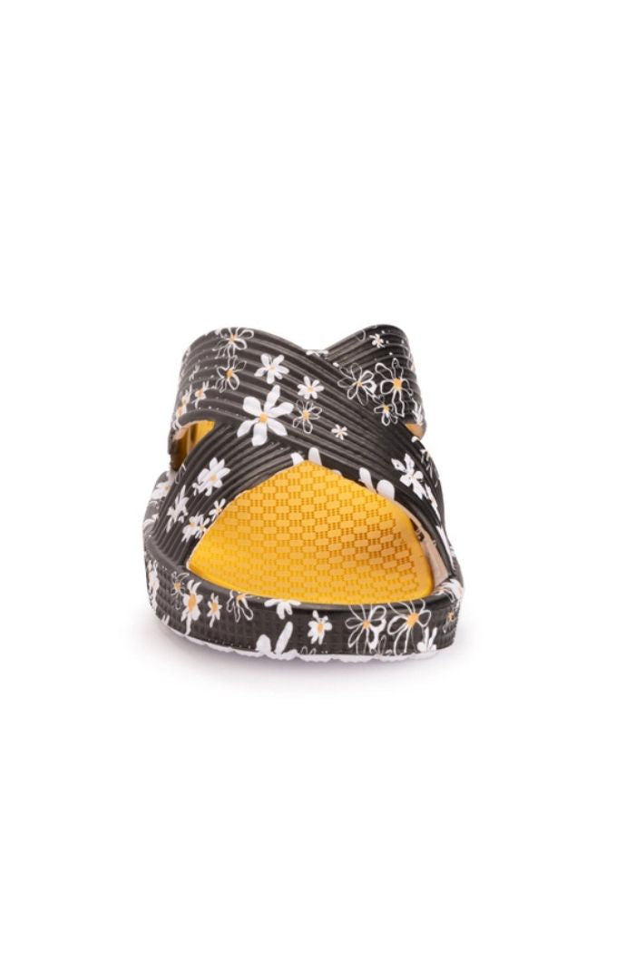 Front view of Black Floral Slip-On Sandals with white and yellow patterns, a textured yellow footbed, and open toe design. These stylish slip-ons combine comfort with flair.