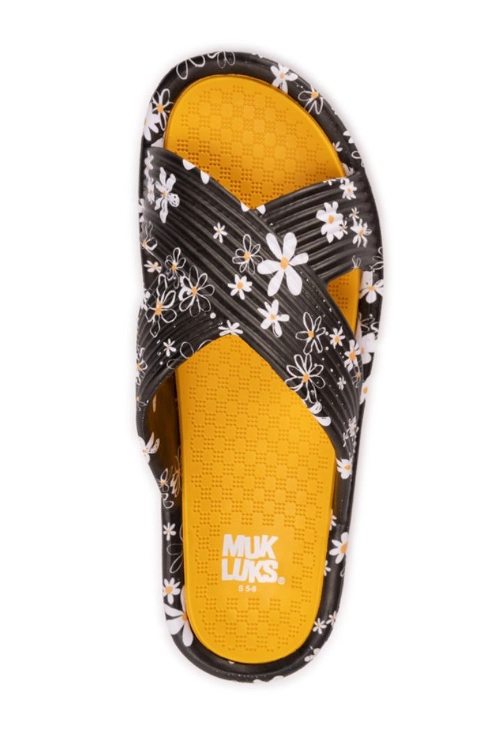 The Black Floral Slip-On Sandals feature black crisscross straps with a white and yellow daisy pattern, a bright yellow EVA footbed for comfort, and the MUK LUKS brand printed in white.