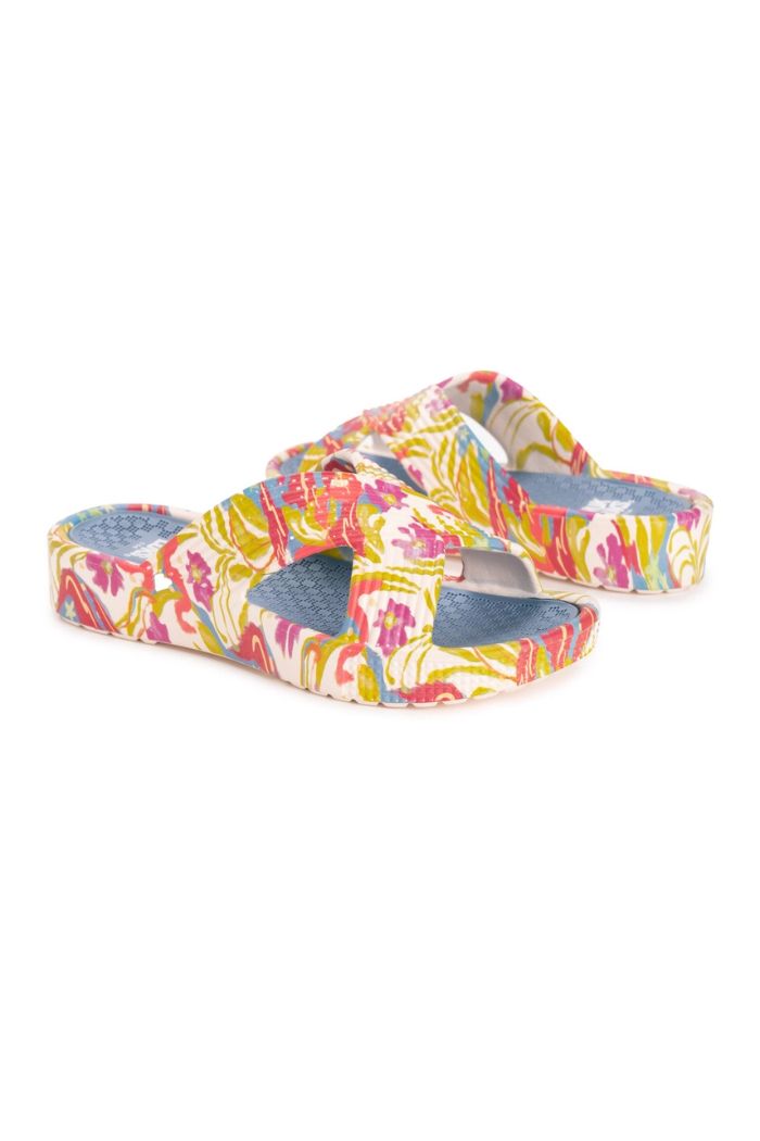 Women's Turquoise Spa Sandals feature slip-on crisscross straps with a vibrant pink, yellow, and green floral pattern on white, and textured blue cushioned footbeds for added comfort.