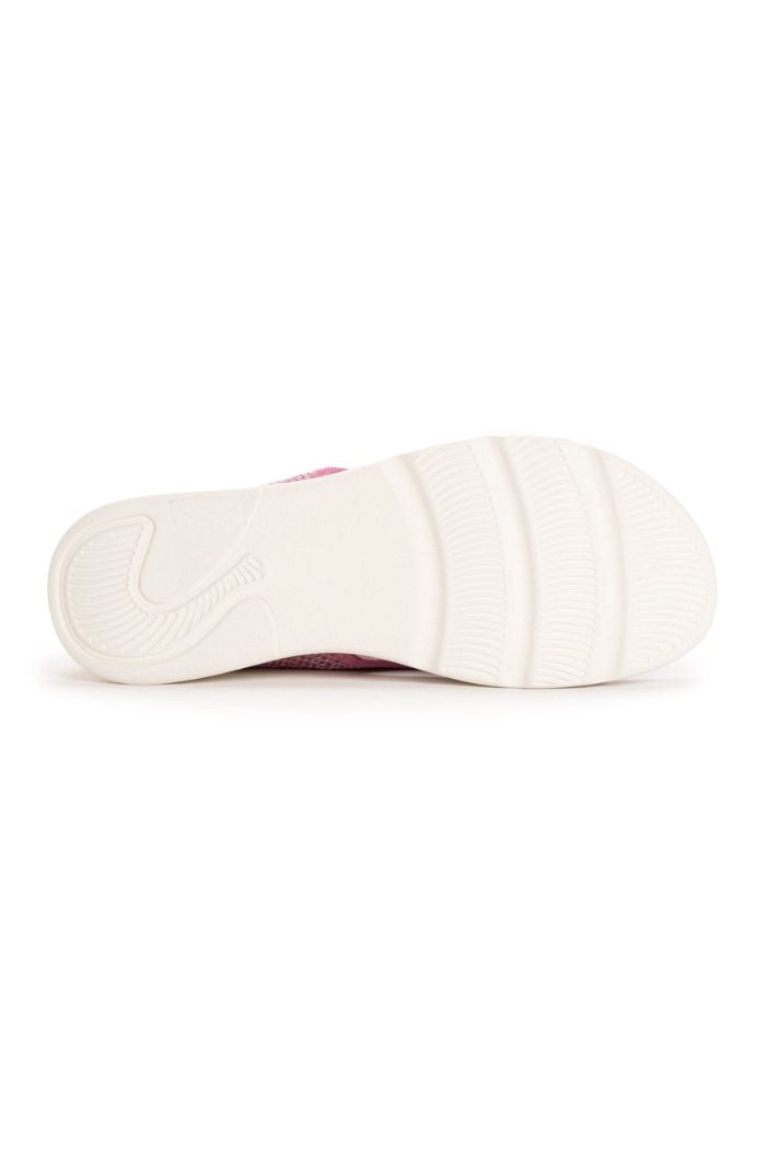The image shows the bottom view of a white rubber sole with textured grip patterns and the edge of a pink knit upper, like that on Muk Luks Zahara Sandals.