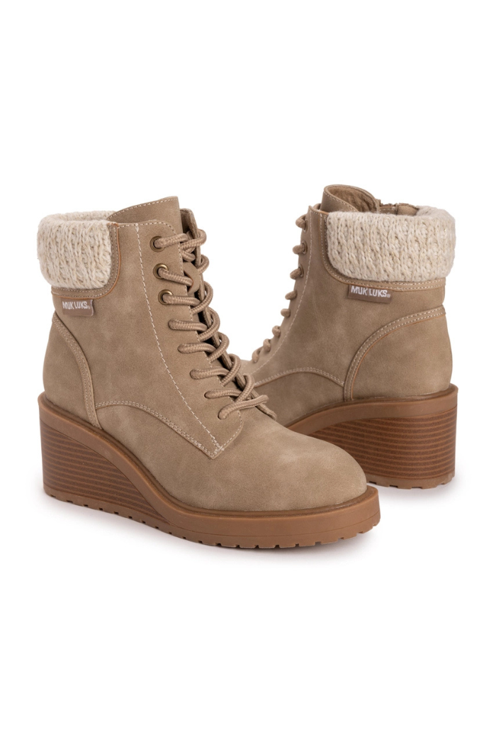 The Sky Solange Wedge Boots feature a tan faux suede finish, lace-up fronts, ribbed rubber soles, and knitted ankle cuffs for cozy style. Labeled on the sides, these boots combine comfort and fashion.