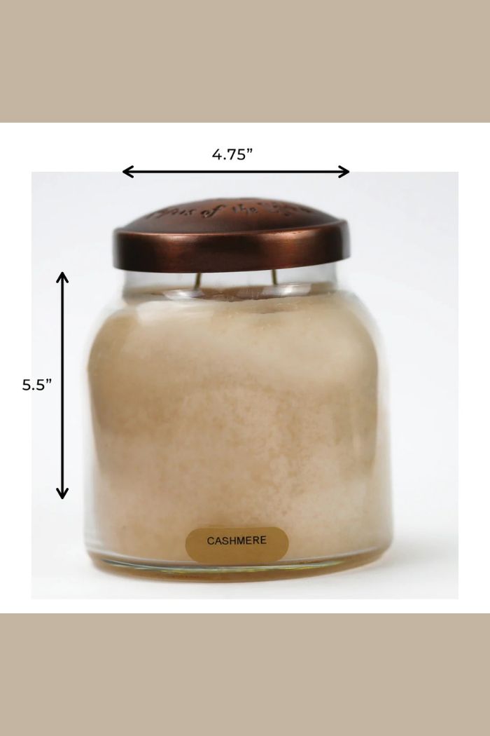 The Papa 34oz Candle is a large scented candle in a decorative jar with a copper-colored lid, labeled Cashmere. It measures 5.5" tall by 4.75" wide, as shown by double-headed arrows indicating its dimensions.