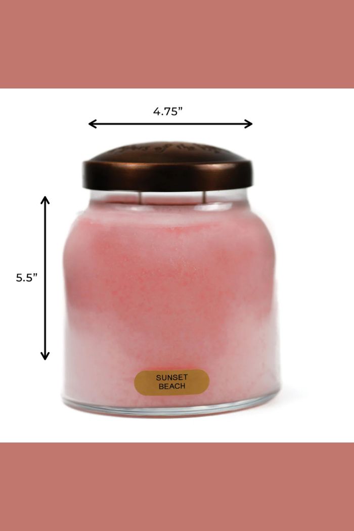 The Papa 34oz Candle is a pink decorative jar candle labeled “Sunset Beach” with a bronze lid, measuring 5.5" tall and 4.75" wide, shown with measurement arrows.