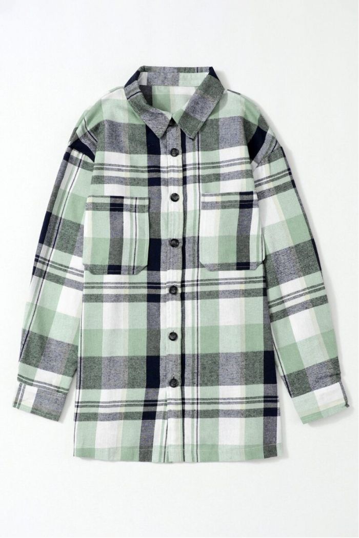 The Plaid Button Up Shirt has green, white, black, and gray checks, long sleeves, a collar, and two chest pockets. It's shown laid flat on a light background.