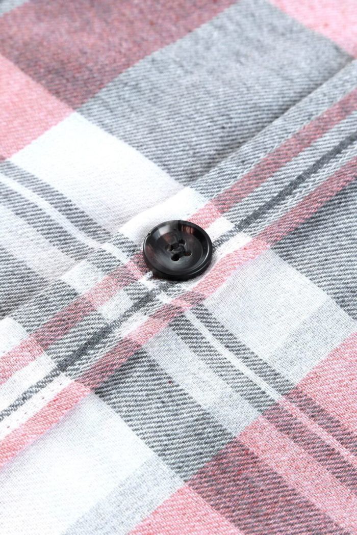 Close-up of the Plaid Button Up Shirt in pink, white, and gray shades, featuring a black button sewn at the intersection of the plaid pattern.