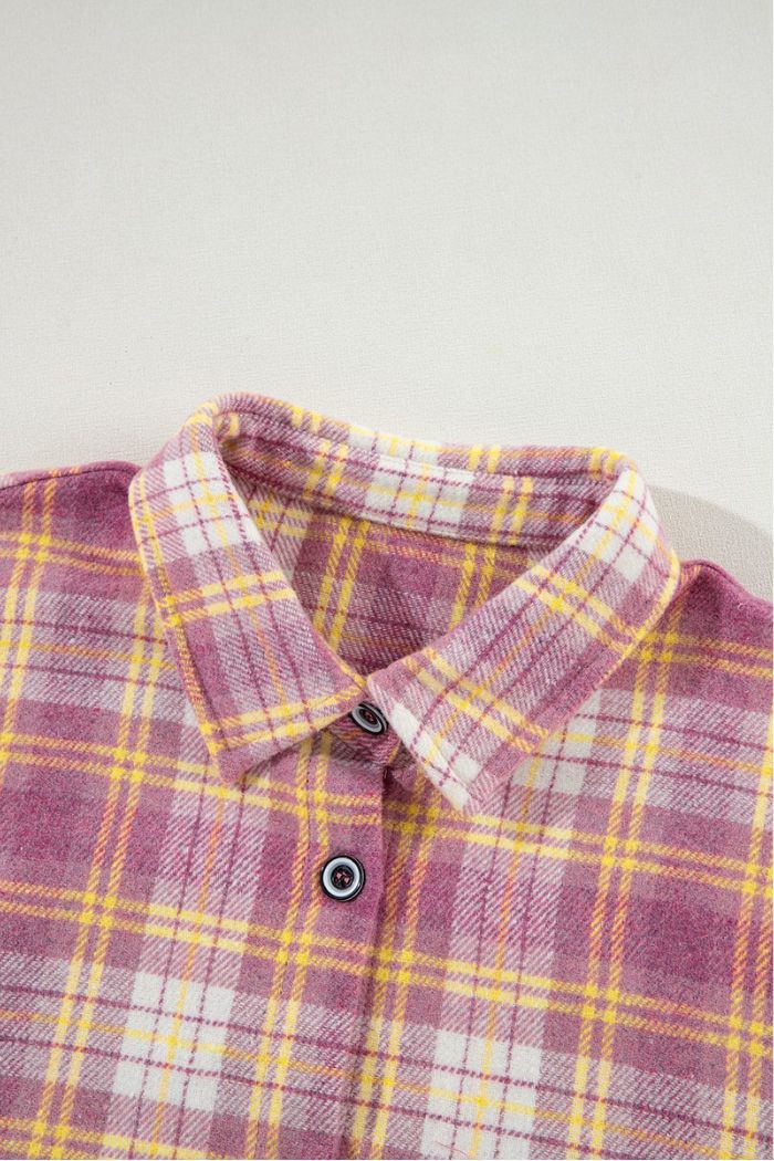 The Pink Plaid Shacket features yellow and white accents, a collared neckline, and two front buttons. Laid flat on a light surface, it's perfect as a women's transitional jacket for casual looks.