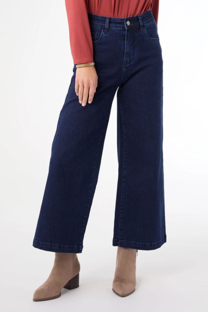 A person models the Everstretch Cropped Wide Jeans in dark blue stretch denim with a rust long-sleeved top and taupe ankle boots. Only the lower half is visible, pictured against a plain white background.