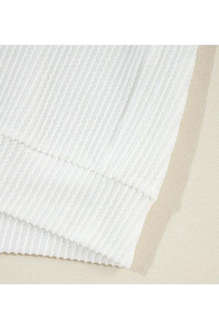 A close-up of the USA Flag Graphic Sweatshirt in white ribbed fabric, featuring textured vertical lines. The image highlights its corner and edge on a light beige surface, showcasing the quality and comfort of this casual top.