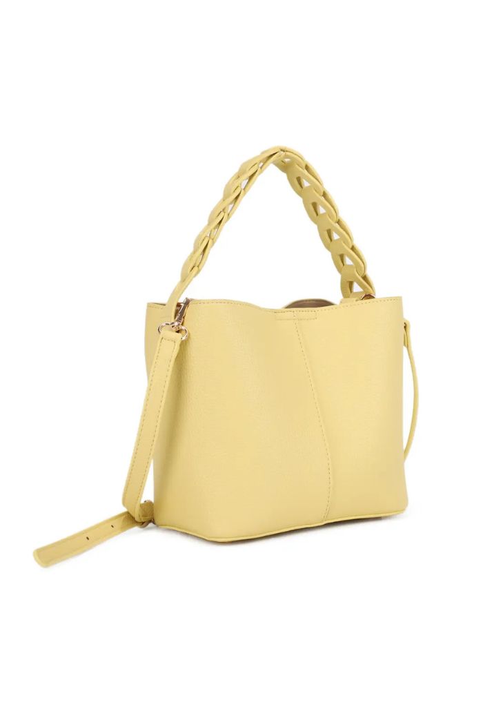 The Lorna Crossbody Bag is a yellow faux leather handbag with a compact, structured shape, textured braided handle, and adjustable shoulder strap, shown against a white background.