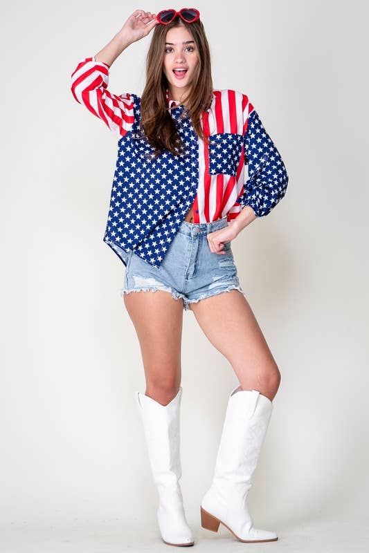 A woman poses in a Patriotic Button Shirt, denim shorts, white cowboy boots, and red heart-shaped sunglasses against a plain light background.