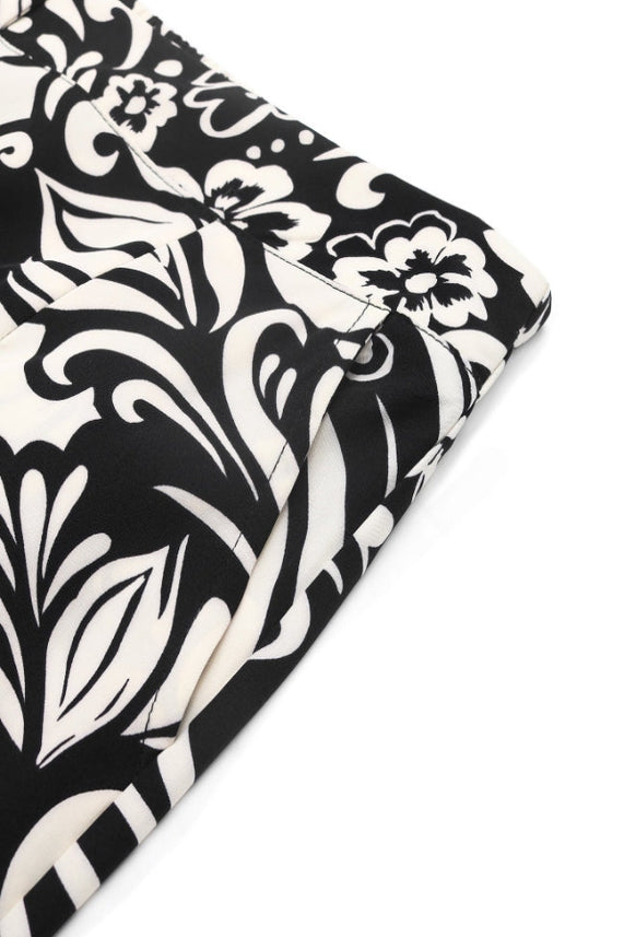 Close-up of Boho Wide Leg Pants with a black and white floral paisley print, high-rise elastic waistband, smooth fabric, and side pocket. The graphic design adds bold style to these trendy wide leg pants.