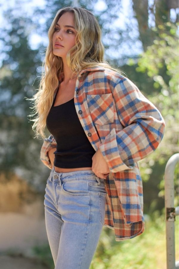 Person wearing a relaxed fit, orange and blue Plaid Wool Blend Shacket over a black tank top and light wash jeans.