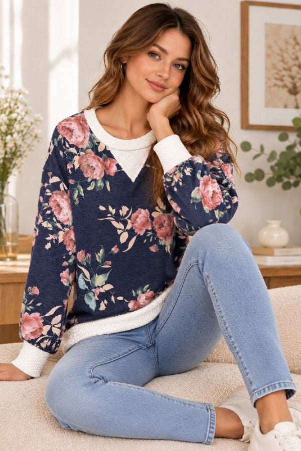 Floral Ribbed Sweatshirt: a long-sleeved, relaxed-fit navy blue sweatshirt in soft, stretchy fabric, featuring a pink floral print and a white ribbed collar, hem, and cuffs.