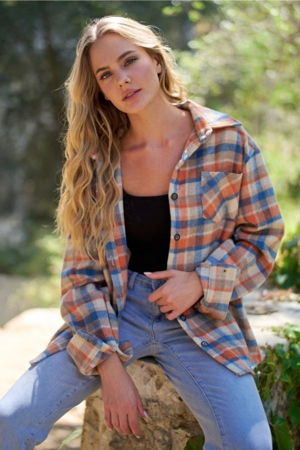 A person wearing a relaxed fit, blue and orange Plaid Wool Blend Shacket over a black tank top and blue jeans.