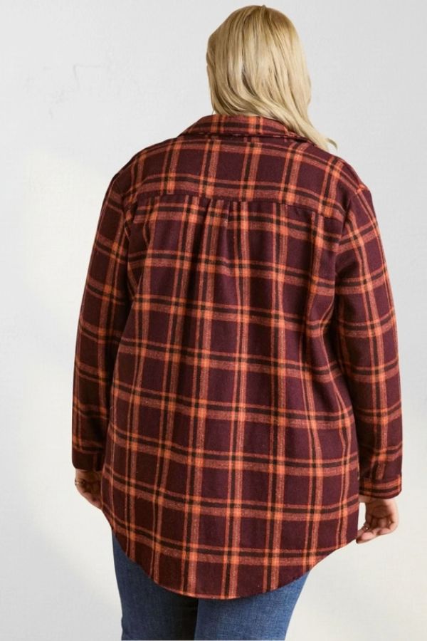 A person viewed from behind wearing a Curvy Plaid Flannel Shirt in an oversized, burgundy and orange plaid pattern with a curved hem.