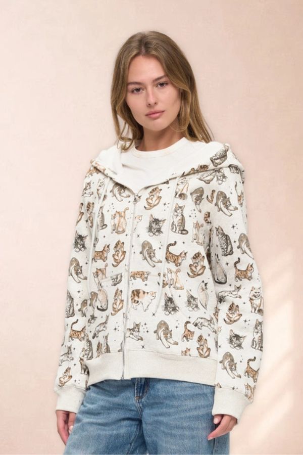 Celestial Cat Print zip-up hoodie featuring an oversized fit with a repeating pattern of cats and small stars on a light background.