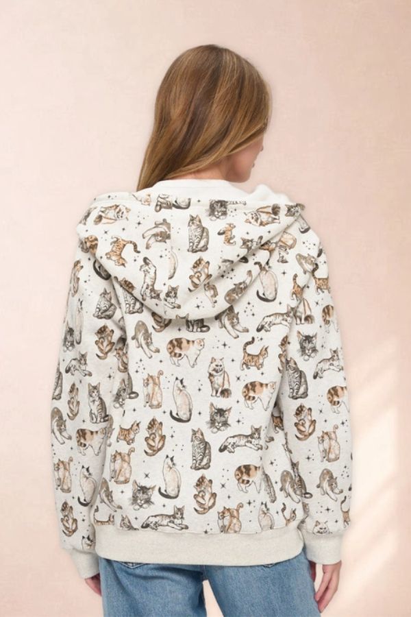 A person wearing an oversized Celestial Cat Print Zip Hoodie featuring various cats and small stars.