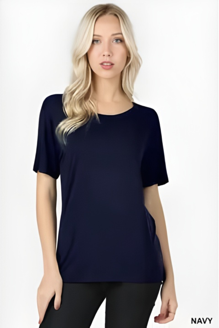 A woman with long blonde hair models a plain, short-sleeve navy blue Plus Size Rayon Tee and black pants against a white background. "NAVY" is displayed in the bottom right corner.
