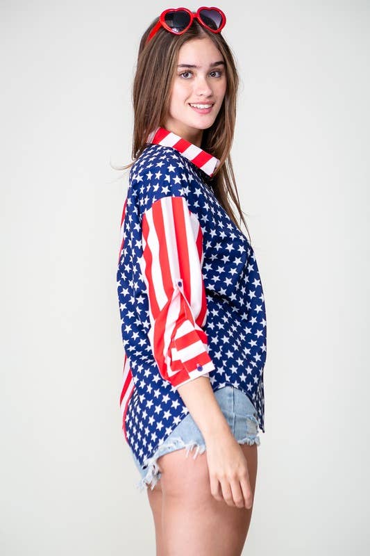 A young woman in a Patriotic Button Shirt, denim shorts, and red heart-shaped sunglasses stands sideways and smiles against a plain background.