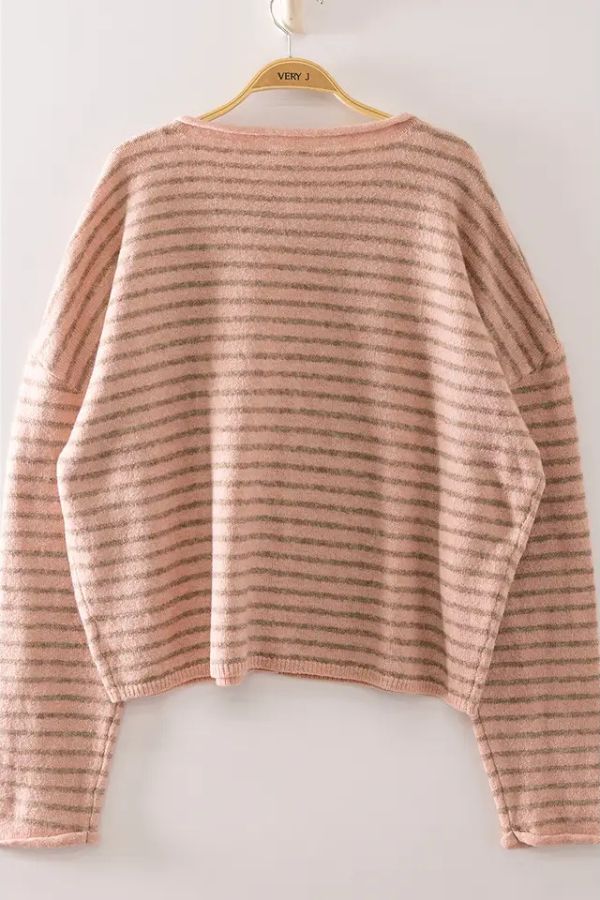 A Striped Button Front Sweater in pink and gray hangs on a wooden hanger against a plain white wall. This oversized sweater features long sleeves and classic stripes, making it a comfortable and stylish addition to your wardrobe.