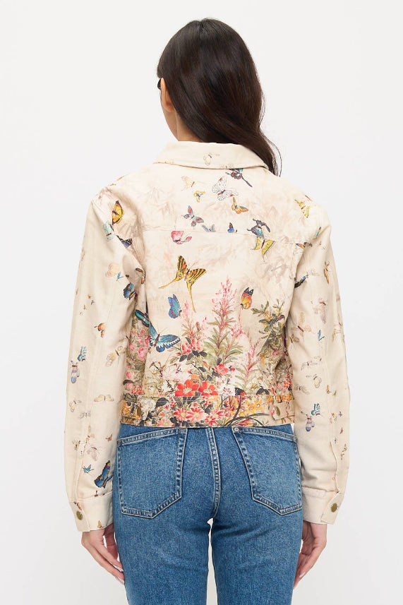 A woman with long dark hair, seen from behind, models the Butterfly Floral Jacket with blue jeans against a plain white background.