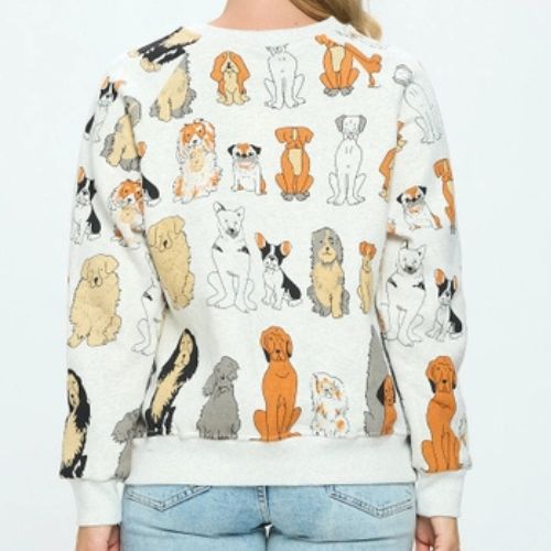 A person is shown from the back wearing the Dog Print Crewneck Sweatshirt, a light-colored crewneck decorated with various illustrated dogs in different poses and colors printed all over, styled with blue jeans—an ideal gift for any dog lover.