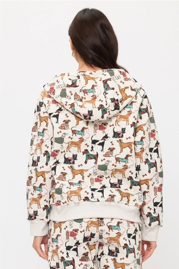A person with long brown hair is shown from the back against a plain white background wearing the Holiday Dogs Zip Up Hoodie and matching pants set featuring a colorful dog print.