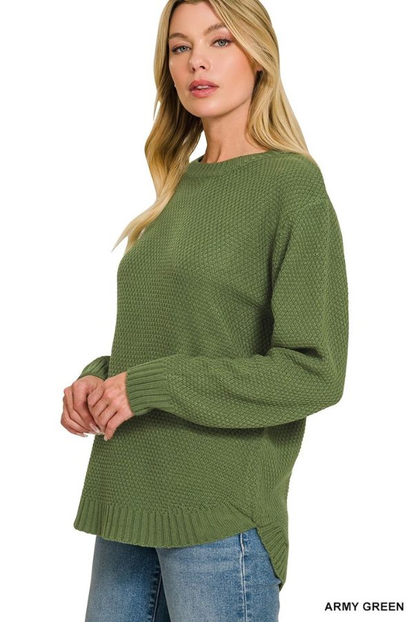 A woman wearing the Everyday Crew Neck Sweater in army green—featuring a relaxed fit, unique textured pattern, and comfortable loose silhouette—paired with blue jeans stands facing slightly left against a white background.